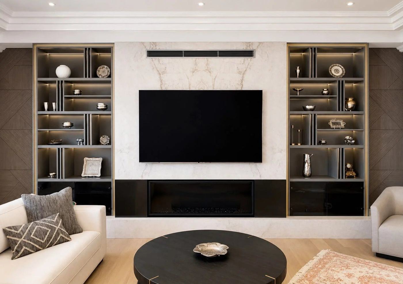 Finished basement media wall with a marble-look TV surround, linear fireplace and lit display shelving in Maple, by NewGen Renovations Vaughan