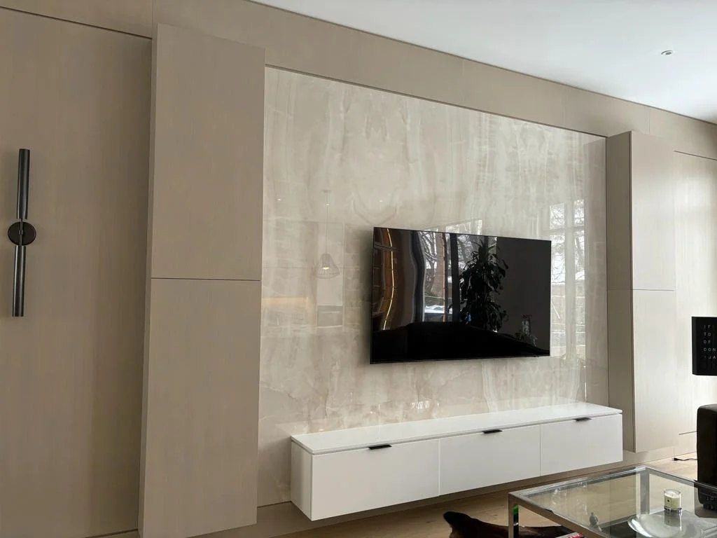 Basement TV wall in onyx-look porcelain with oak-look panels and a floating media cabinet in Thornhill, by NewGen Renovations Vaughan