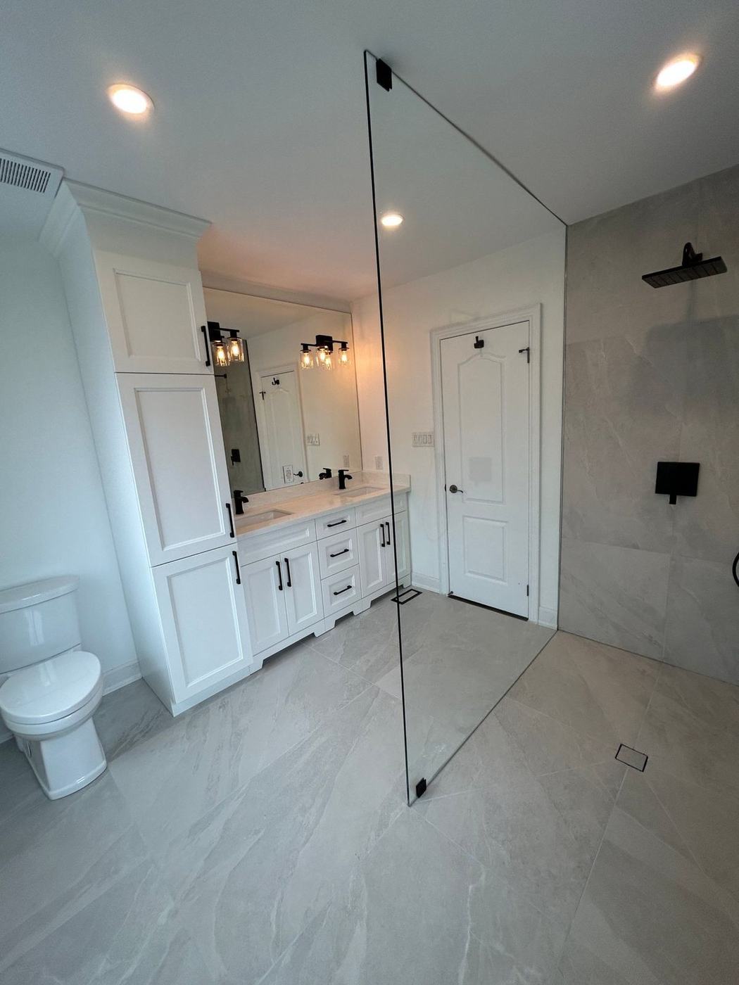 Large-format stone-look porcelain tile running level into a curbless shower floor, installed by NewGen Renovations Vaughan